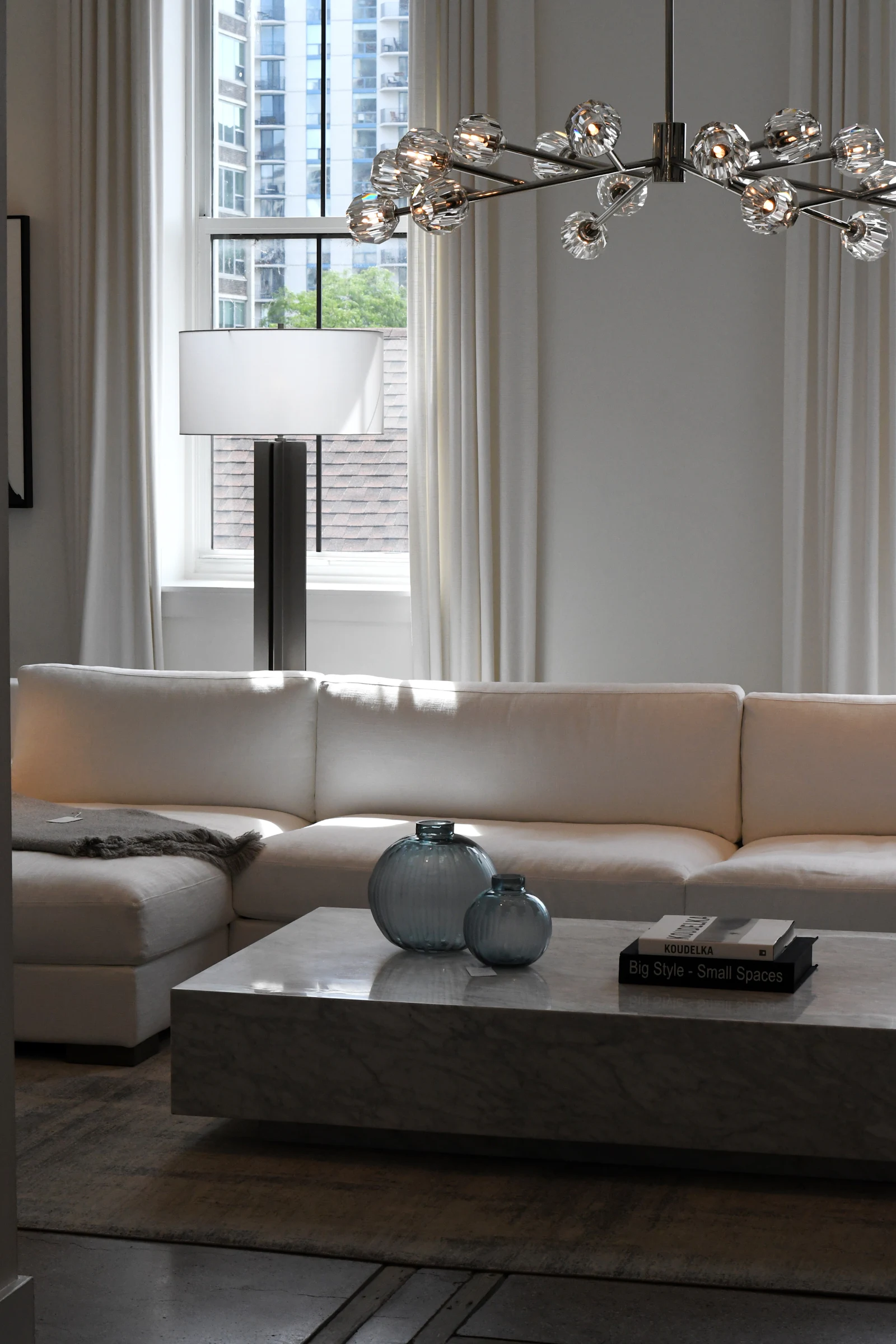 Low white sofa with glass vases on a coffee table