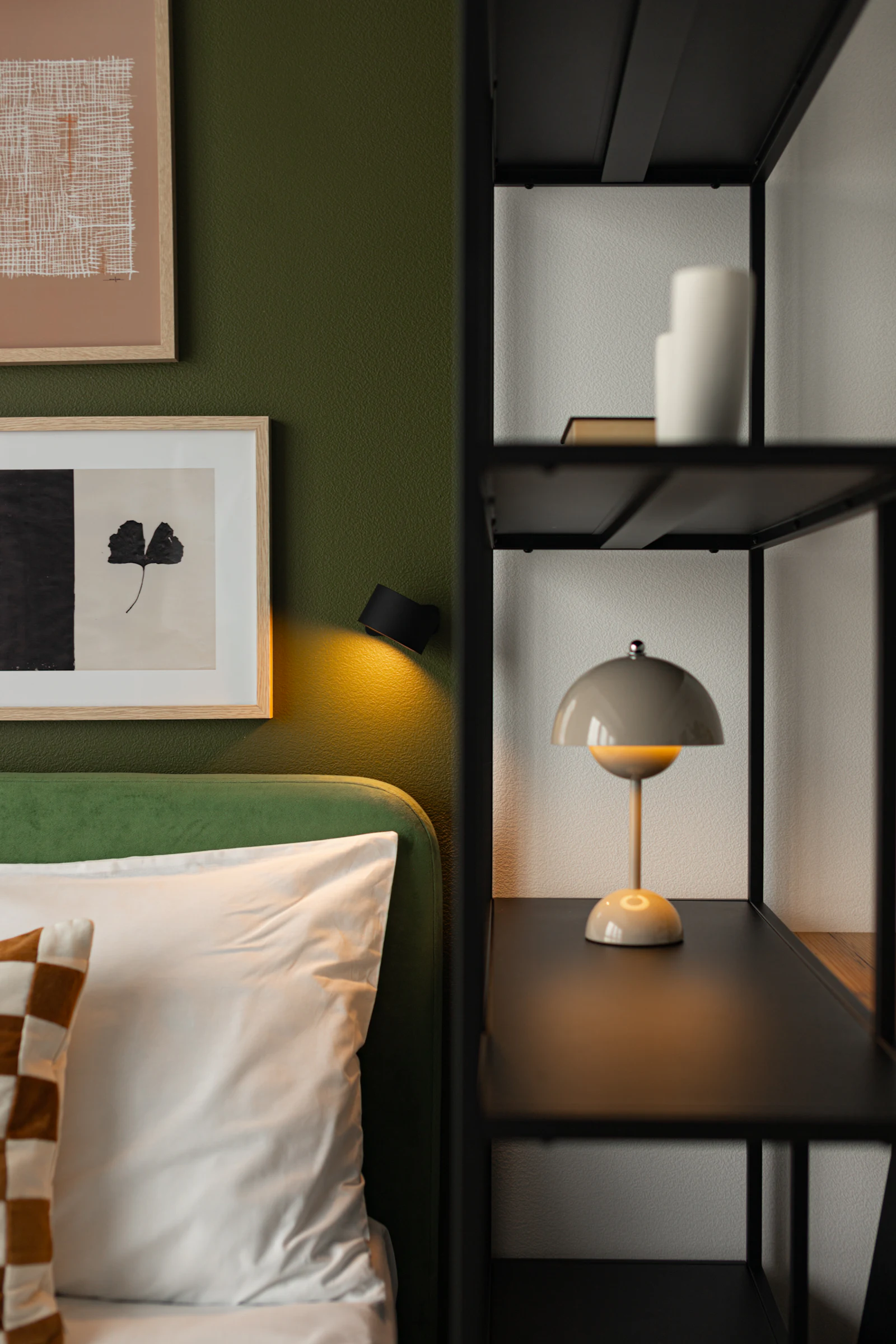 Bedroom with an olive green upholstered headboard and a mushroom table lamp