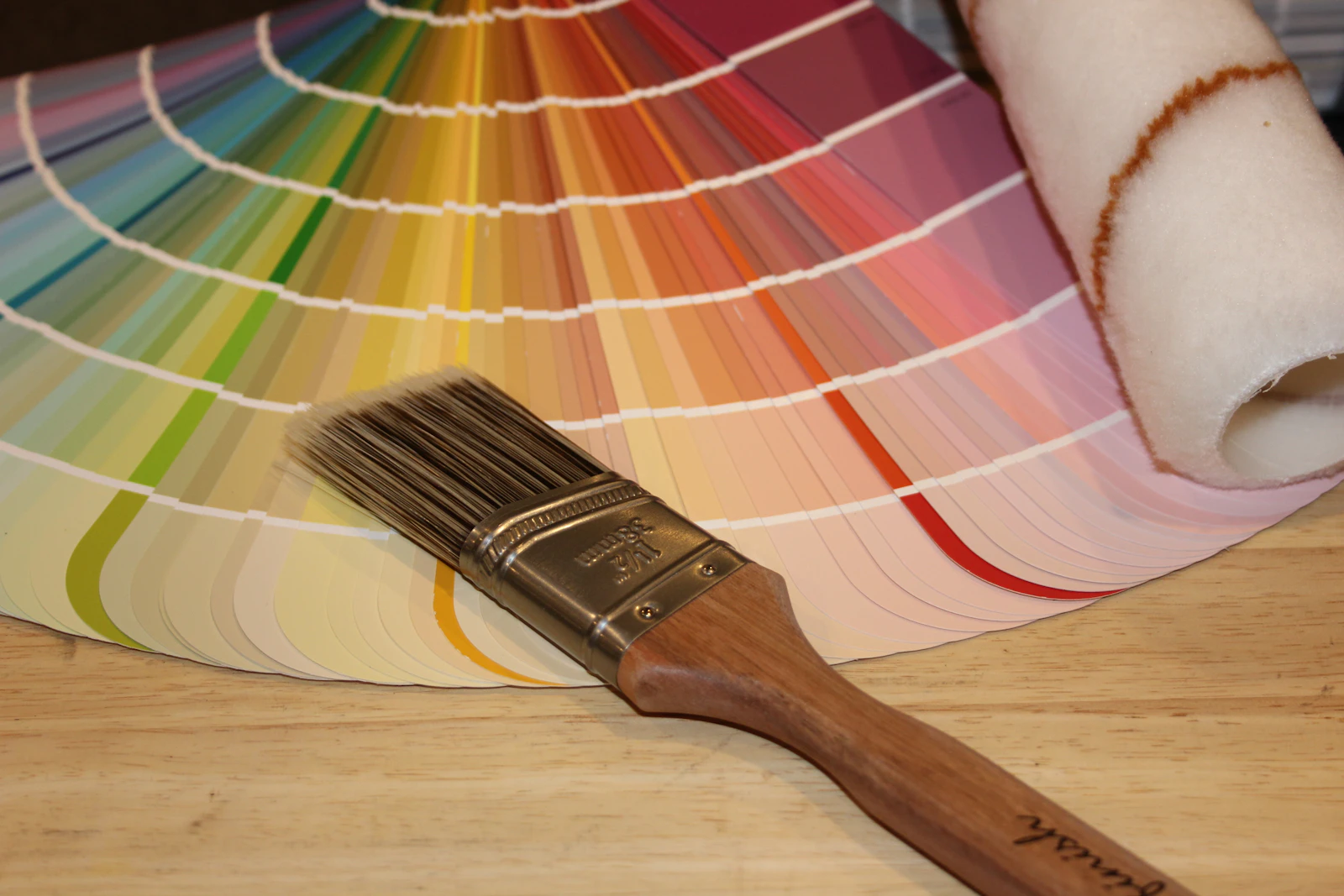 Paintbrush resting on a fan of paint colour swatches
