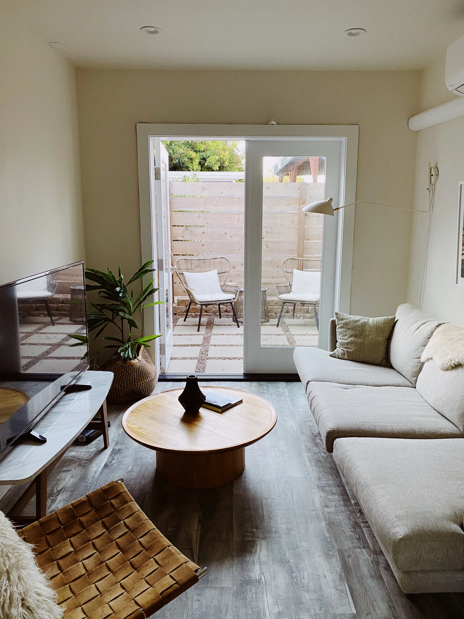 Small living room with patio doors, a round coffee table and a white sofa