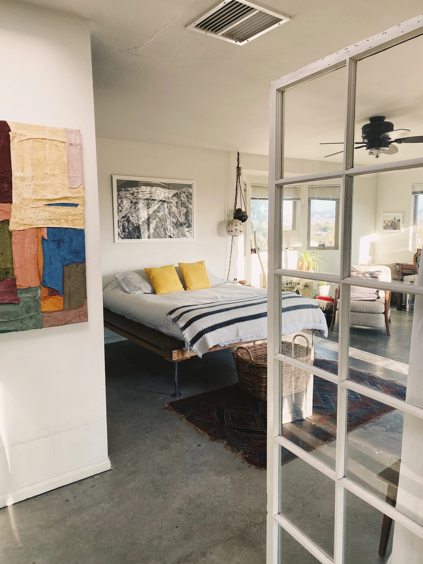White bed linen on a bed in a bright bedroom with a glazed door